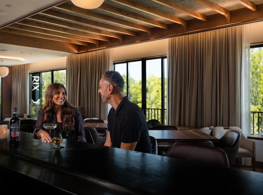 Two Guests sitting at bar at Rix at Ada, Hotel enjoying drinks.